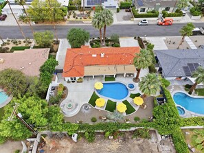 A residential property with a swimming pool, patio with umbrellas, and a red-roofed house. - "La Veranda" a Movie Colony Palm Springs Resort Pool and View Home, #069334 (Palm Springs)