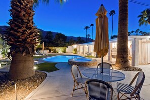 A pool area with lounge chairs, a table, and umbrellas. - "La Veranda" a Movie Colony Palm Springs Resort Pool and View Home, #069334 (Palm Springs)
