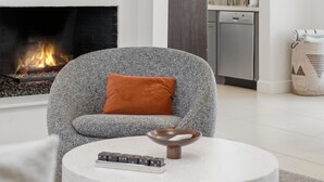 A modern living room with a fireplace, a flat-screen TV, and a round coffee table. - "La Veranda" a Movie Colony Palm Springs Resort Pool and View Home, #069334 (Palm Springs)