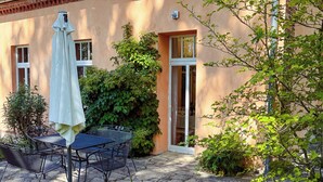A patio with a table and chairs, a covered umbrella, and a garden with various plants. - Apartment 2 - Morning awakening - light-flooded maisonette in the count's forester's lodge (Temmen-Ringenwalde)
