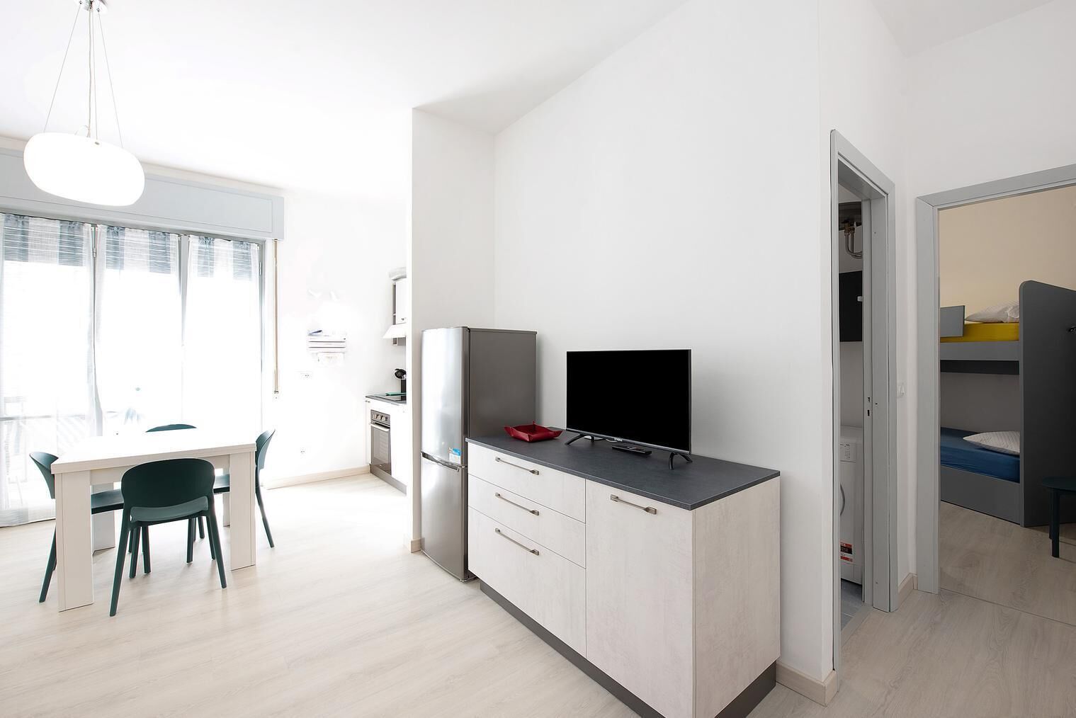 Ett modernt kök med matplats, TV och en inbyggd garderob.