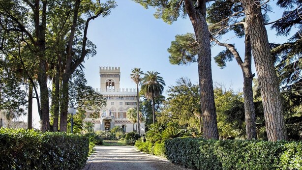 A pathway leading to a historic building with a tower, surrounded by mature trees and well-maintained hedges. - Casa Azzurra - One Bedroom Apartment, Sleeps 4 (Arenzano)