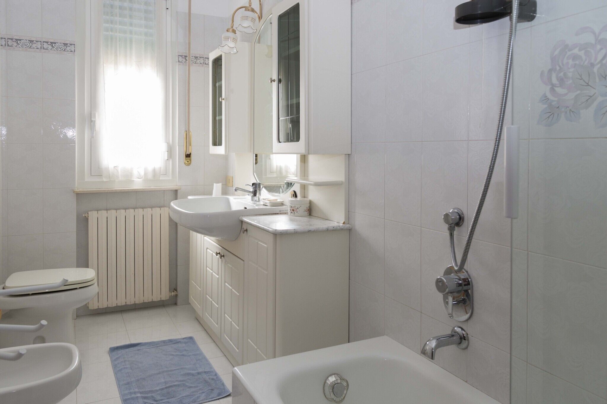 Un baño con inodoro, lavabo, bañera y ducha.