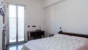 Un dormitorio con cama, escritorio y silla.