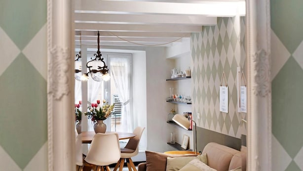 A dining area with a table, chairs, and a chandelier. There is a sofa and a lamp in the foreground. - Casa Fiordaliso - One Bedroom Apartment, Sleeps 4 (Arenzano)