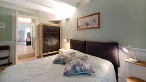 A bedroom with a bed, pillows, a nightstand, a lamp, a wardrobe, and a painting on the wall. - Casa Fiordaliso - One Bedroom Apartment, Sleeps 4 (Arenzano)