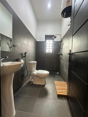 Casa de banho moderna com sanita, lavatório e zona de duche.