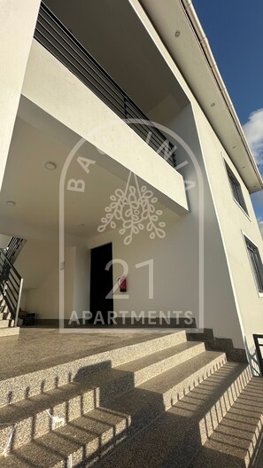 Um edifício de apartamentos moderno com uma escadaria que leva à entrada.