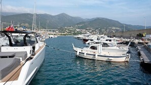 A marina with several boats docked, a mountainous backdrop, and a clear sky. - Casa Olivette - Two Bedroom Apartment, Sleeps 5 (Arenzano)