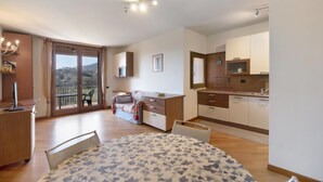 Un appartamento moderno con balcone, zona pranzo, cucina e soggiorno.