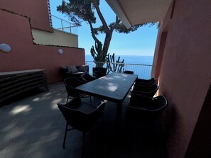 An outdoor patio with a table and chairs, a cactus plant, and a view of the sea. - L'Ile d'Azur - Three Bedroom Villa, Sleeps 6 (Arenzano)
