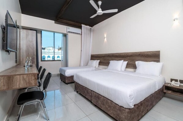 Une chambre d’hôtel avec deux lits, un bureau et une chaise.