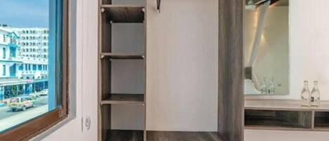 Une chambre d’hôtel moderne dotée d’une grande armoire, d’un miroir et offrant une vue sur la ville.
