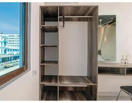 Una habitación de hotel moderna con un armario grande, un espejo y vistas a la ciudad.