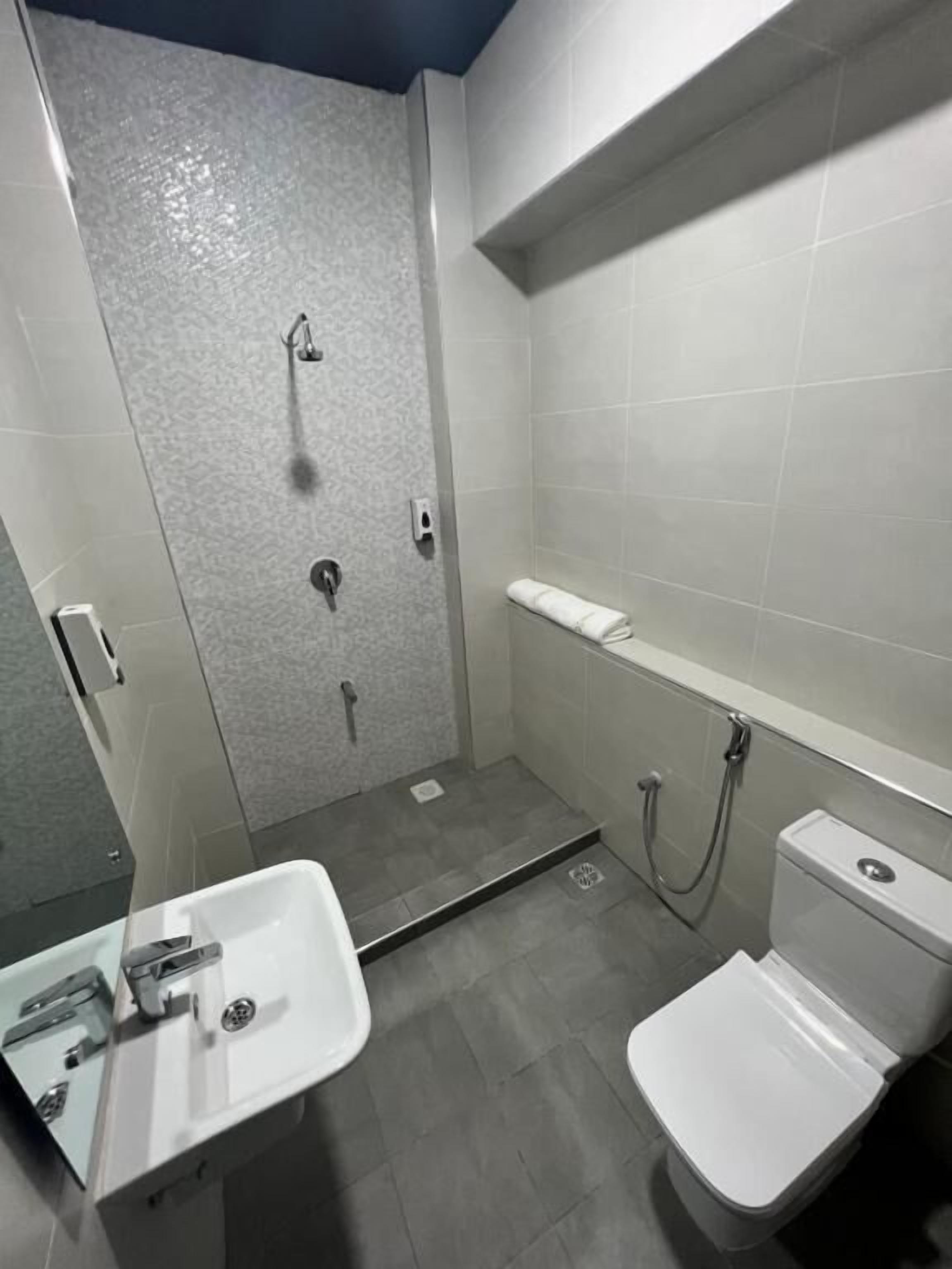 A bathroom with a shower, toilet, and sink.