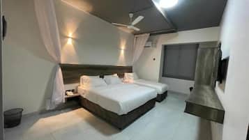 A bedroom with a large bed, a ceiling fan, and a window.