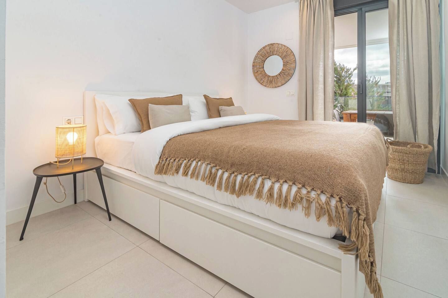 Une chambre à coucher moderne avec un lit, une table de chevet et une vue sur l’extérieur.