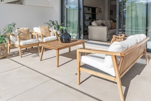 An outdoor seating area with wooden furniture and potted plants. - Lme3bb - Modern Flat With a Stunning 50 m² Terrace (Estepona)
