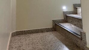 A staircase with a light fixture on the wall and a small window at the top. - Nova Jerusalém Hotel (Goiânia)