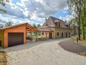 A two-story stone house with a covered porch and a garage. - Elegant 10-guest Villa With Pool & Castle Views (Saint-Medard-d'Excideuil)