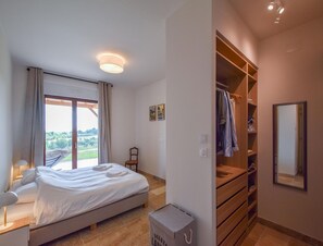 A bedroom with a bed, a wardrobe, a mirror, and a window with curtains. - Elegant 10-guest Villa With Pool & Castle Views (Saint-Medard-d'Excideuil)