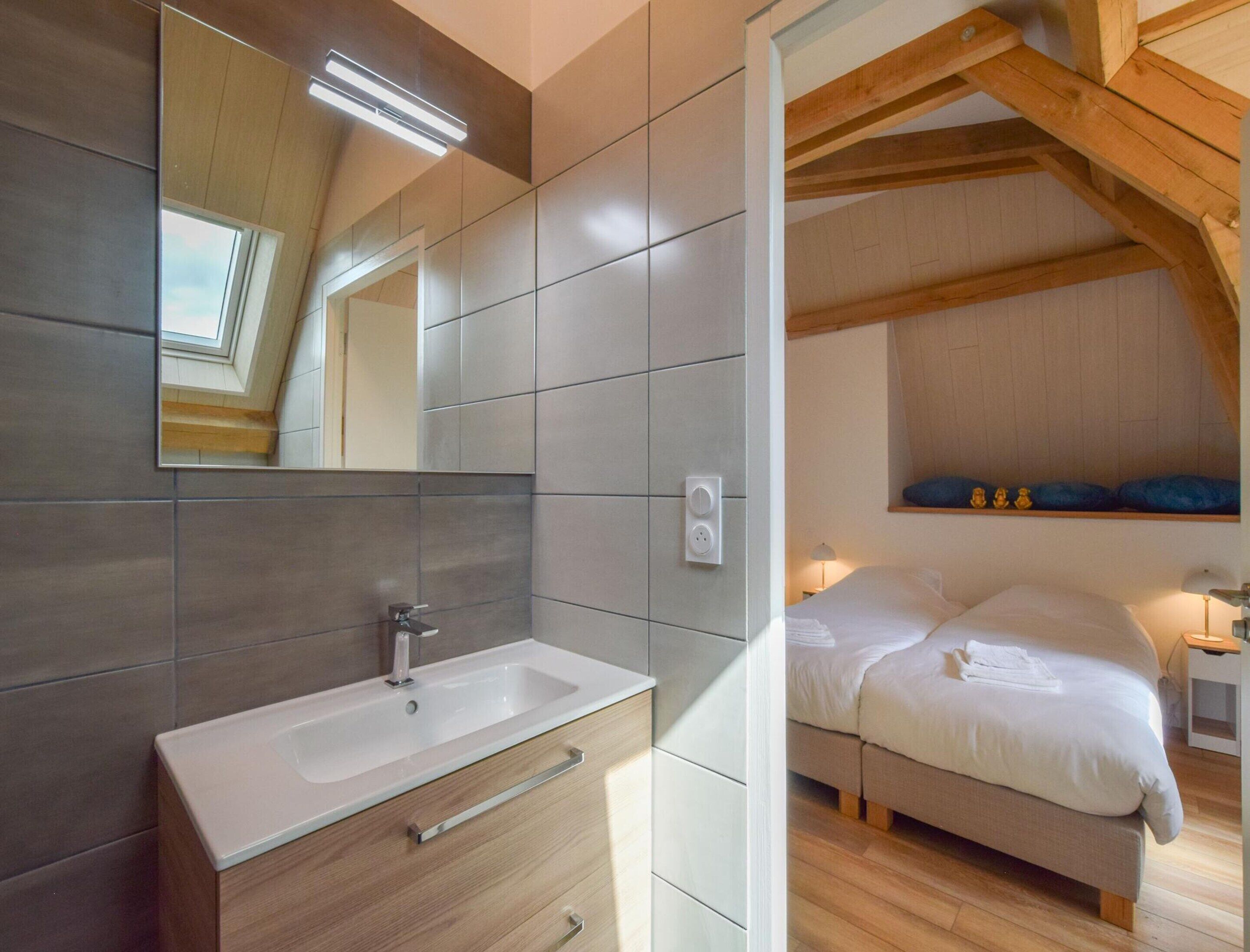 Un dormitorio moderno con una cama grande, una mesita de noche y una lámpara de noche. Se ve una ventana con vistas al exterior.