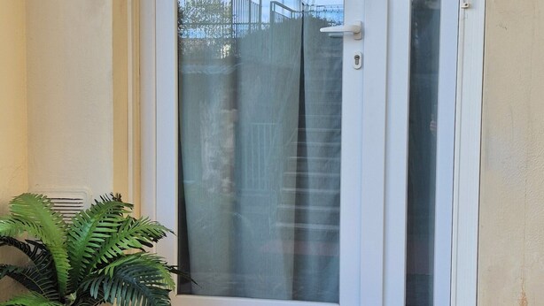 A white door with a glass panel, a potted plant, and a doormat on a stone step. - ViaGiotto Junior 
Welcoming and well-kept apartment in Tuscany (Certaldo)