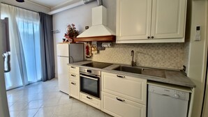 A modern kitchen with white cabinets, a Bosch dishwasher, a built-in oven, and a stainless steel sink. - ViaGiotto Junior 
Welcoming and well-kept apartment in Tuscany (Certaldo)