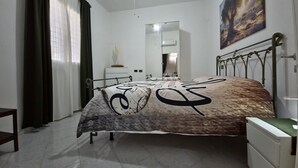 A bedroom with a bed, a dresser, a mirror, and a painting on the wall. - ViaGiotto Junior 
Welcoming and well-kept apartment in Tuscany (Certaldo)
