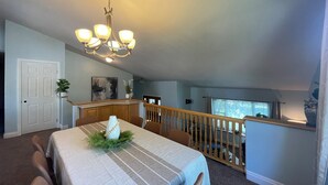 A dining area with a chandelier, a table with a patterned tablecloth, and a view of the kitchen. - Spacious 5-bedroom house in a quiet part of Billings close to entertainment. (Billings)