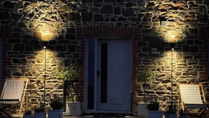 A stone building with a sign reading 'THE DAIRY' and a door. There are potted plants and a chair outside. - The Dairy (Holsworthy)