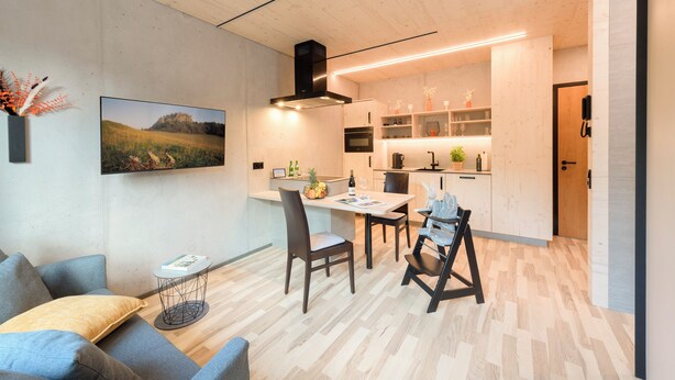 Eine moderne Küche mit Essbereich, Holzboden und einem Bild an der Wand.