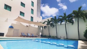 A swimming pool with lounge chairs and palm trees. - Hotel Viajero Plus (Ciudad del Carmen)