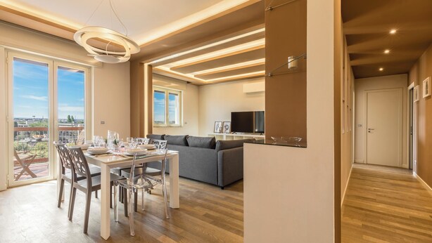 Una sala de estar moderna con comedor, un sofá y una televisión.