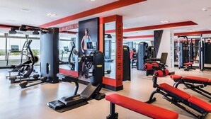 A modern gym with various exercise equipment, motivational posters, and a clear view of the outdoors through large windows. - 2-BR Garza Blanca Exclusive Resort for New Year's 2027 1 full week (PUNTA SAM)