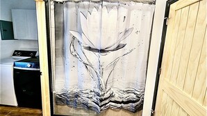 Un baño con cortina de ducha decorada con un diseño de salpicaduras de agua.
