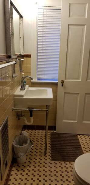 A bathroom with a sink, mirror, window, and toilet. - 3-bedroom house in lovely Halifax for quiet, restful stays (Halifax)