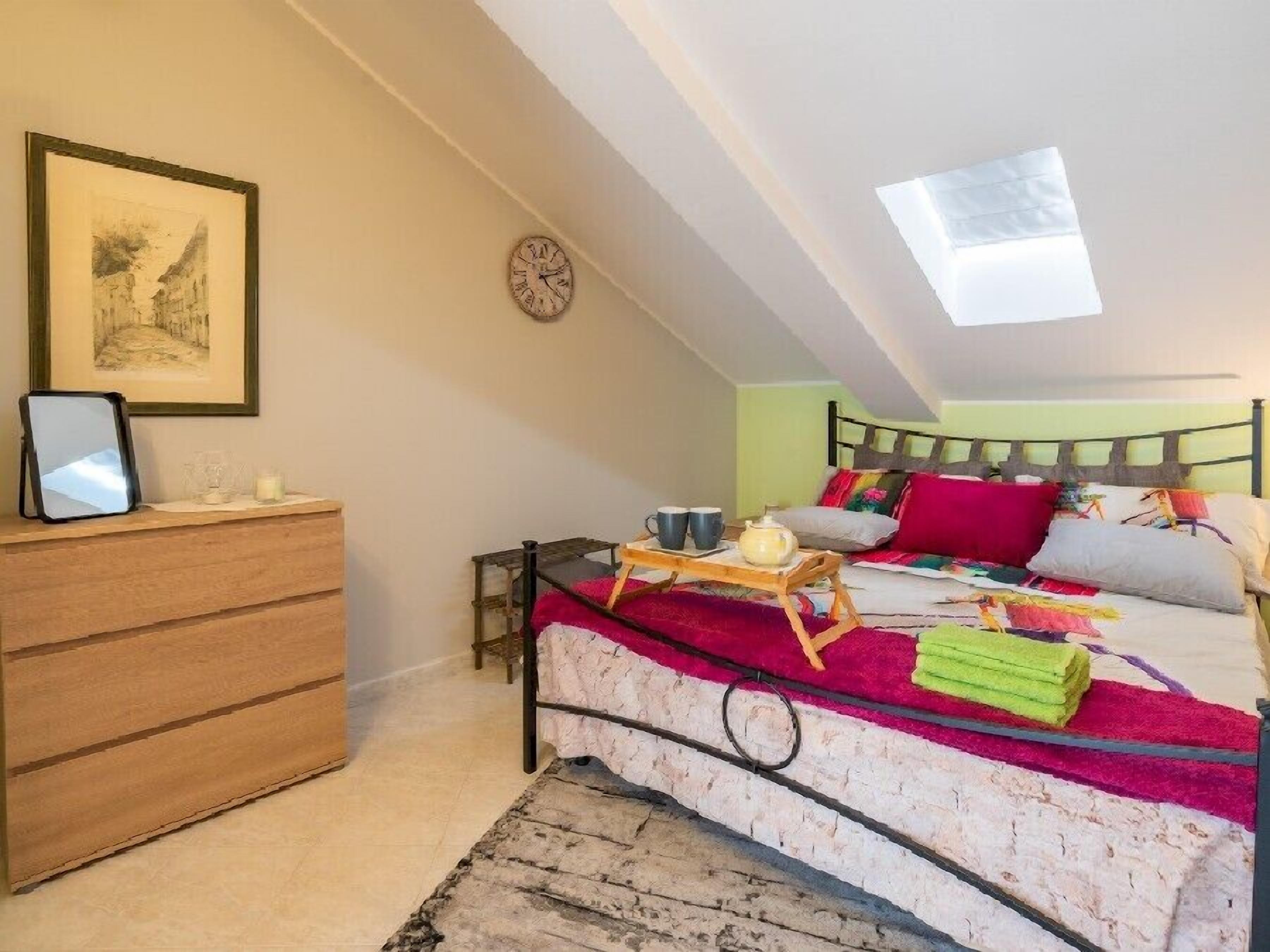 Ein gemütliches Schlafzimmer mit einem Bett, einem Nachttisch und einem gerahmten Bild an der Wand.