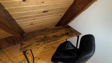 A wooden ceiling with visible beams and a black office chair.