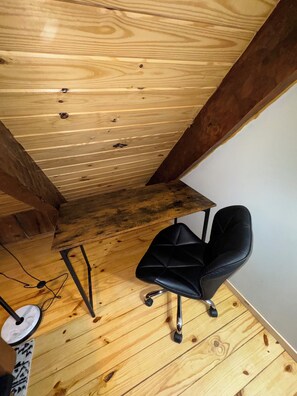 A wooden ceiling with visible beams and a black office chair.