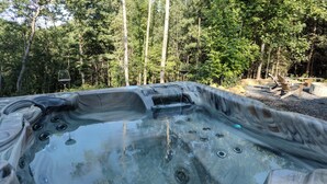 Un jacuzzi rodeado por un bosque.