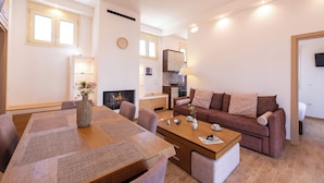 Ein modernes Wohnzimmer mit Esstisch, Sofa und Küchenzeile.