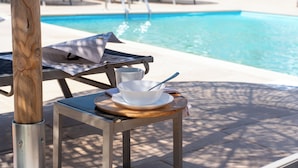 Ein Poolbereich mit Tisch, Schüssel und Löffel, im Hintergrund ein Schwimmbecken.