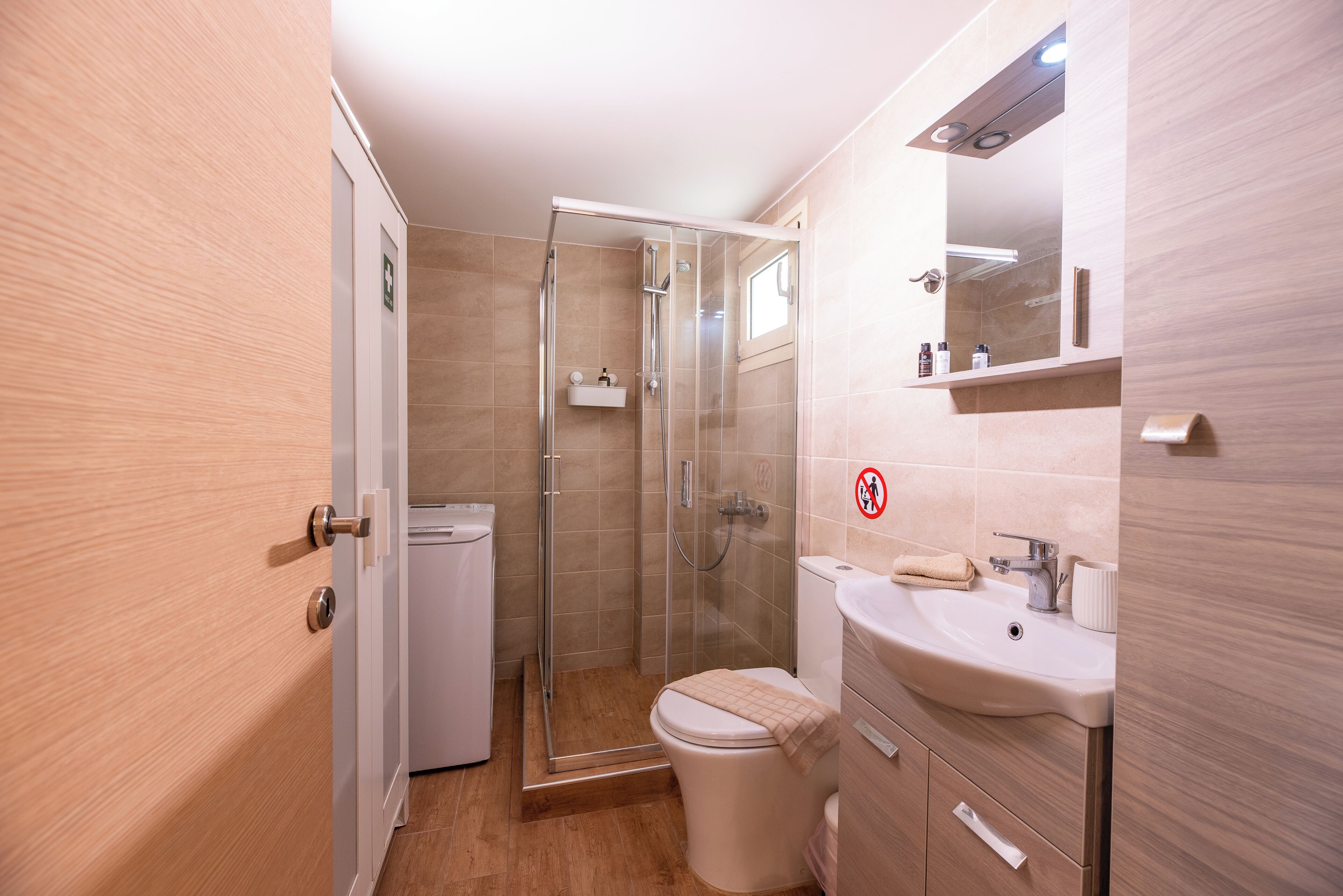 Ein modernes Badezimmer mit Duschkabine aus Glas, Toilette und Waschbecken mit Spiegel.