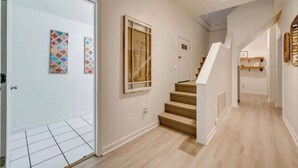 Ein modernes Interieur mit einer Treppe, gefliestem Boden und Kunstwerken an den Wänden.