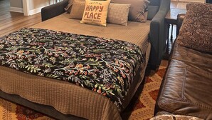 Un salón amplio con una cama grande, un sofá y un comedor.