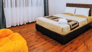 A hotel room with a bed, a large window with sheer curtains, a bright ceiling light, and a wooden floor. - Hotel Casa Santiago (San Juan de Pasto)