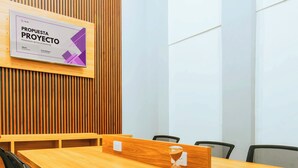 A conference room with a long wooden table, black office chairs, and a whiteboard with a marketing project proposal. - Hotel Casa Santiago (San Juan de Pasto)