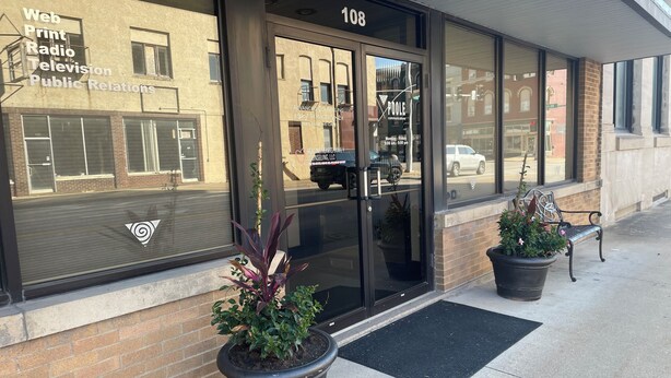 A building with a glass door marked "108" and a sign for "Web Print Radio Television Public Relations." - The Library, 1-queen bed, 1-bedroom apartment in Hannibal awaits your visit. (Hannibal)