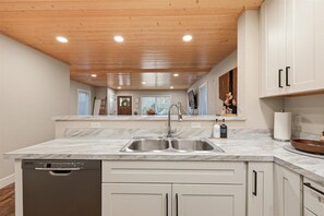 A modern kitchen with marble countertops, stainless steel sink, and wooden ceiling. - *Walk To BSU*HotTub*Parking*300Mbps*Smart TV*W/D*A/C (Boise)